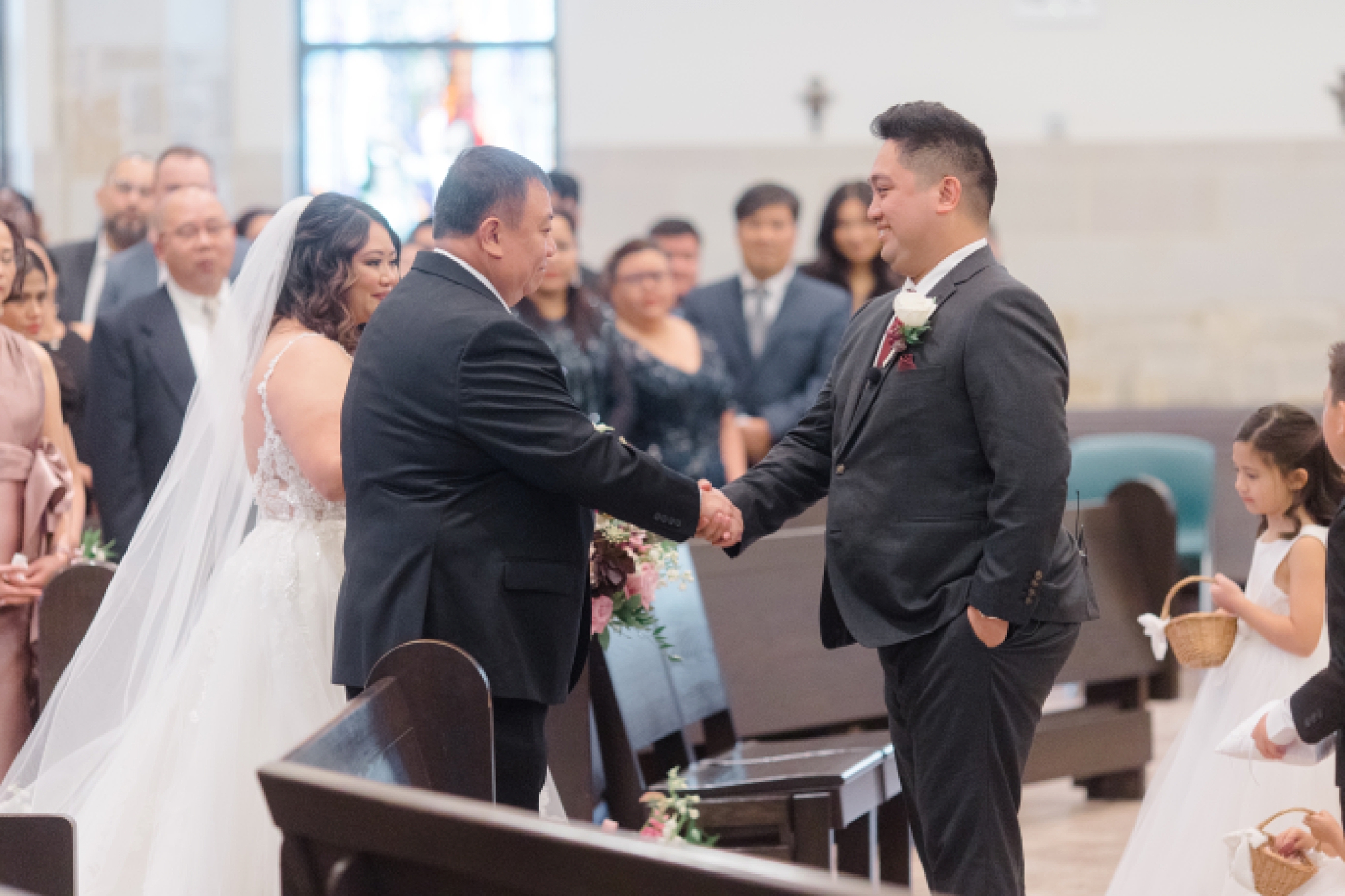 groom shakes bride's father's hand during wedding ceremony at St. Francis of Assisi Catholic Church Frisco
