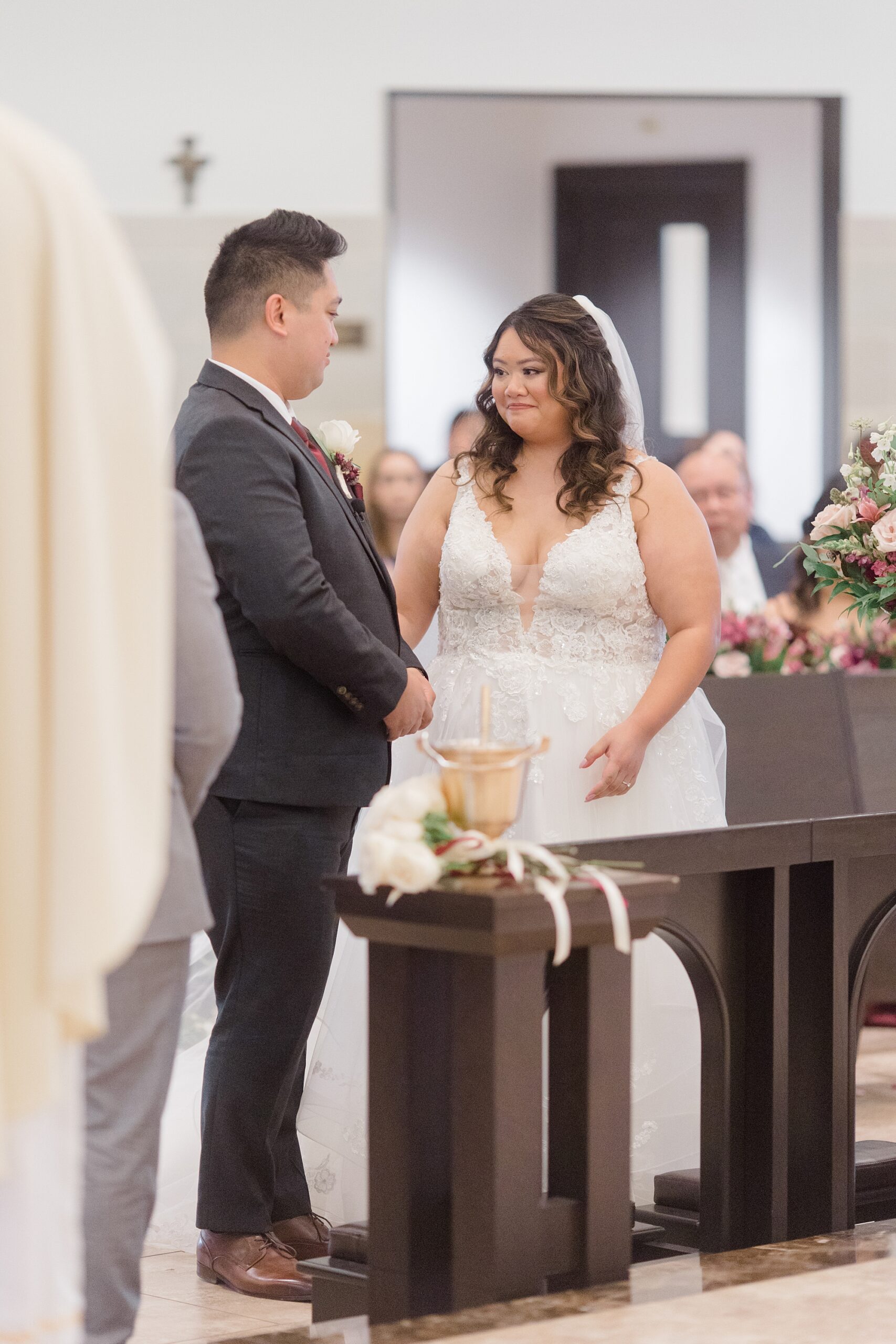 bride and groom smile together during ceremony at St. Francis of Assisi Catholic Church Frisco