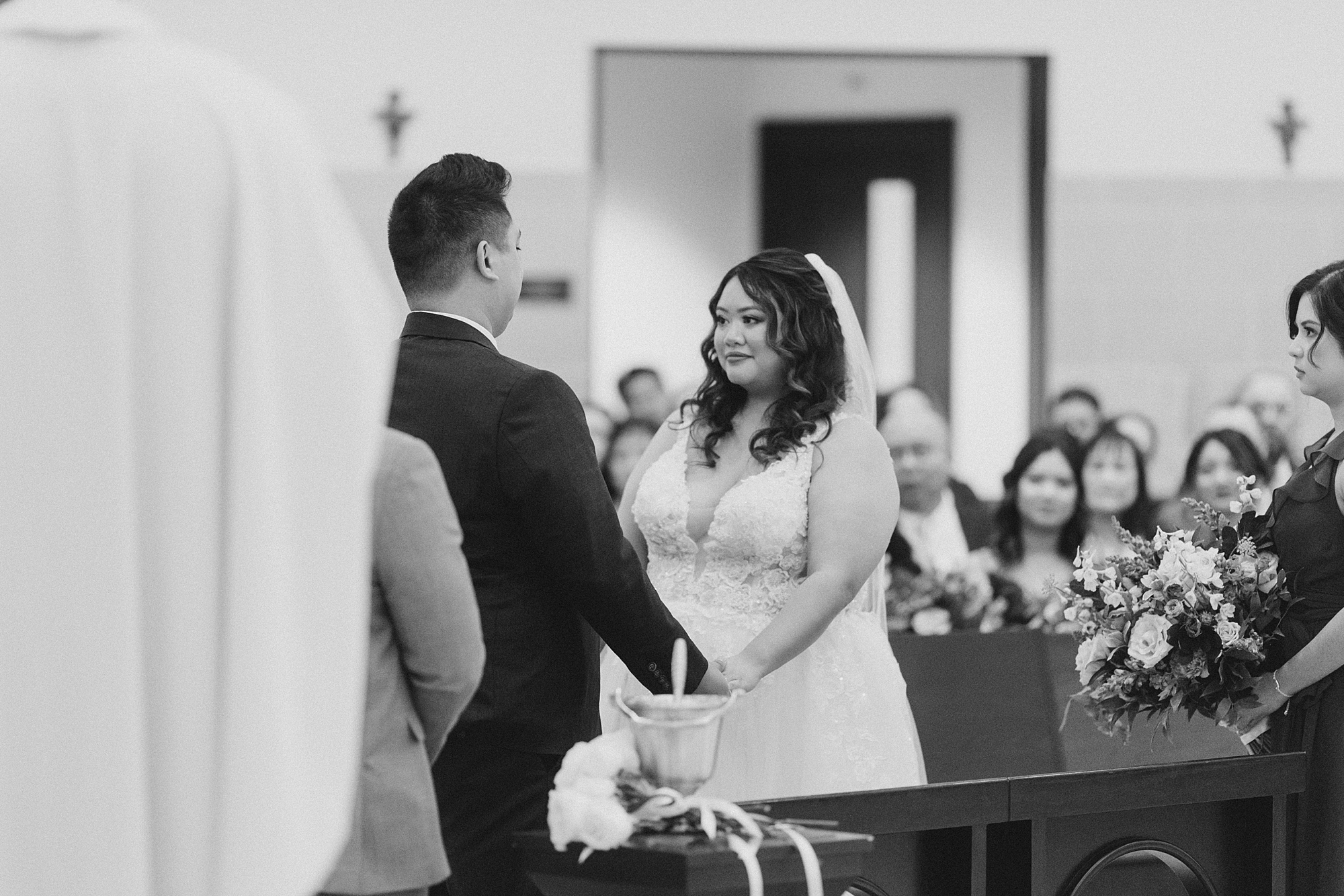 bride holds groom's hands during ceremony at St. Francis of Assisi Catholic Church Frisco