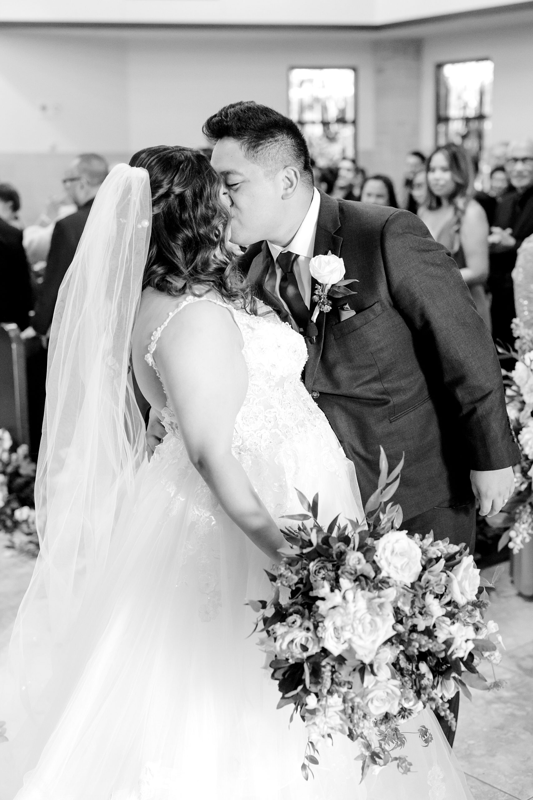 newlyweds kiss in aisle at St. Francis of Assisi Catholic Church Frisco